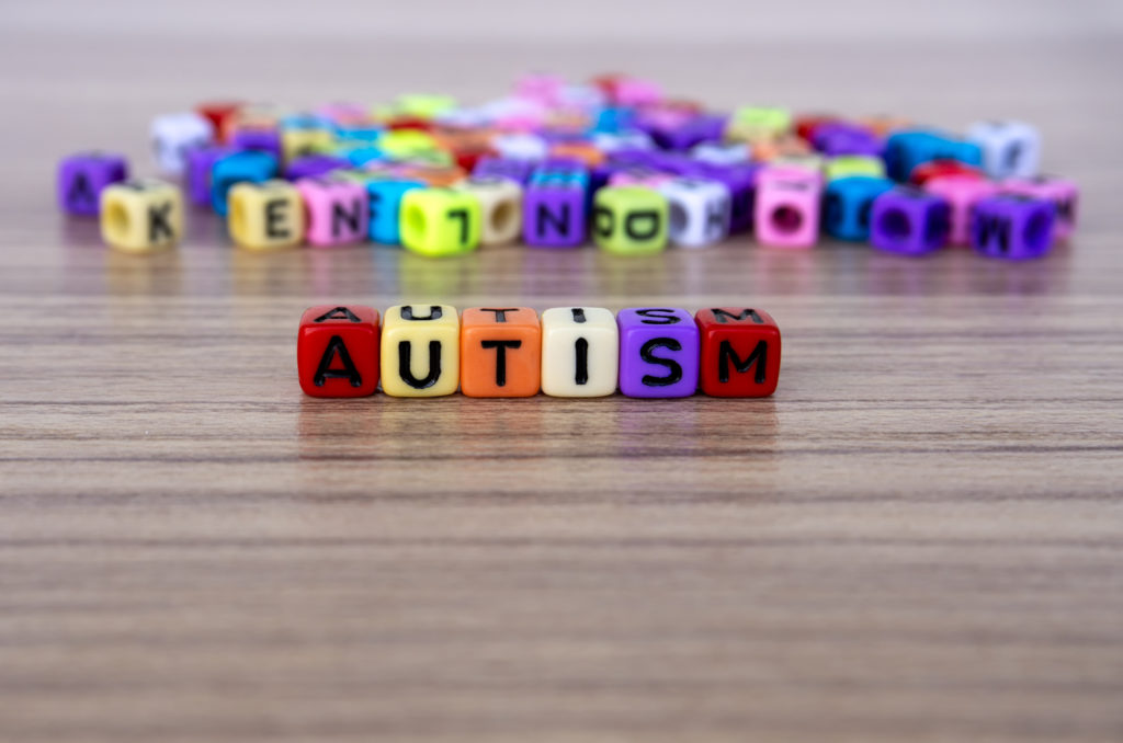 Multi-colored square beads that spell AUTISM