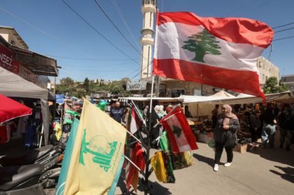 A woman walks near flags inside the Nabatieh market that reopened after it was destroyed during the last war between Israe...
