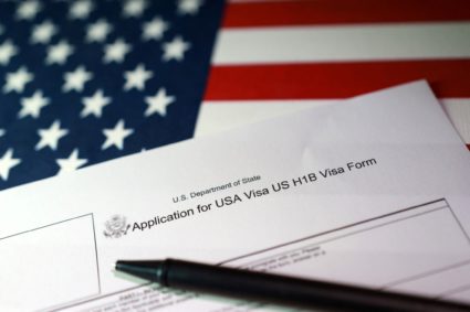 Illustration shows U.S. flag and U.S. H-1B Visa application form