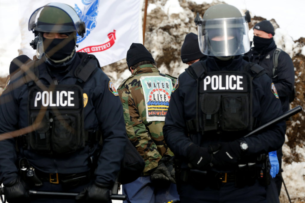Police detain a protester in the main opposition camp against the Dakota Access oil pipeline near Cannon Ball