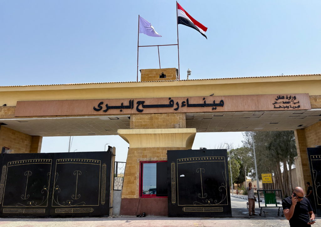 People stand at the Rafah border crossing between Egypt and the Gaza Strip, in Rafah