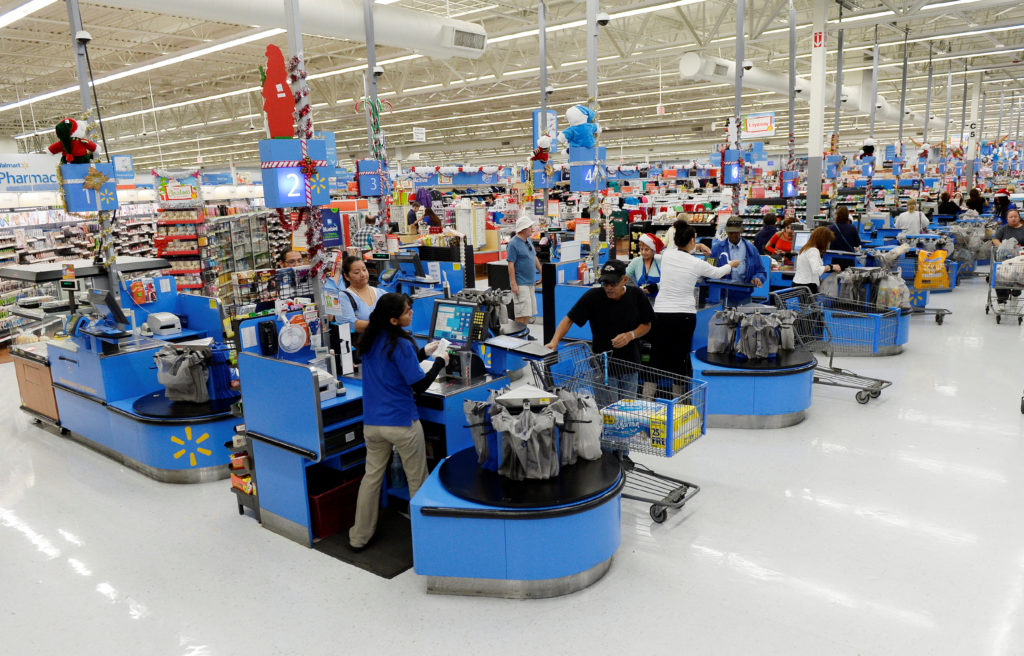 FILE PHOTO: Cashiers work at the checkout lanes of a Walmart store in the Porter Ranch section of Los Angeles