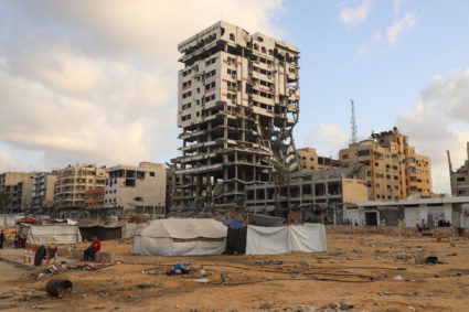 Displaced Palestinians sit next to the tents, during the Israeli military offensive, in Gaza City