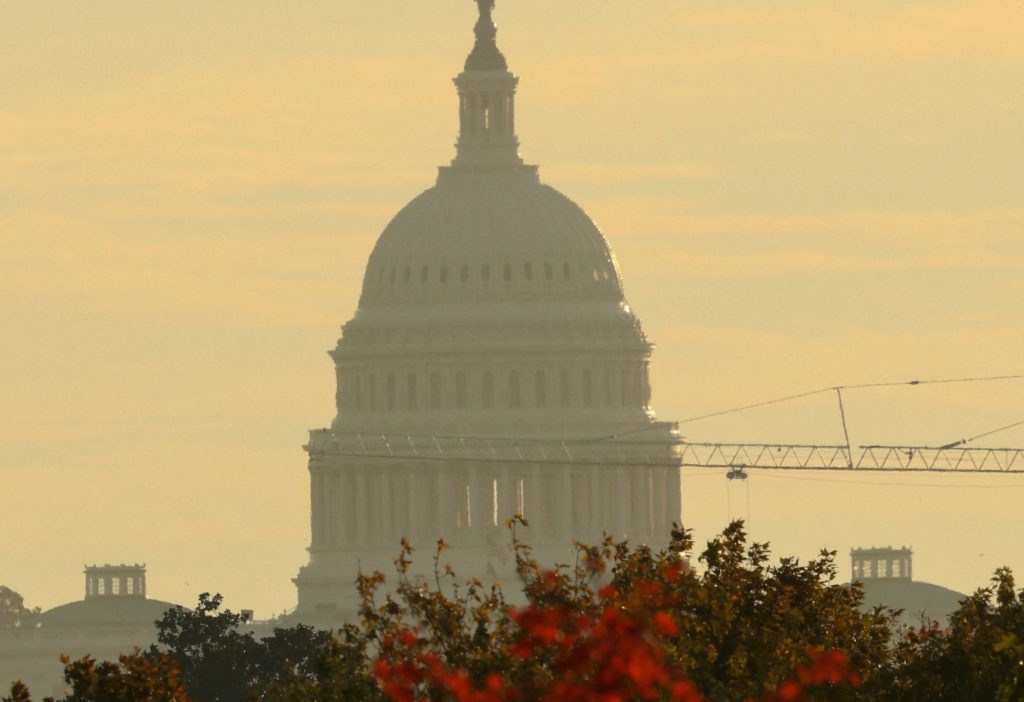The dome of the U.S. Capitol seen in the backgound of a tree in autumn colors in Washington
