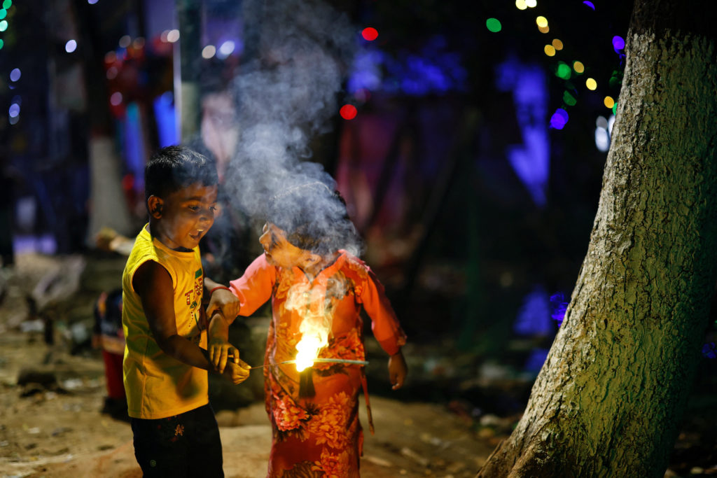 Children plays with firecrackers as they celebrate Diwali, in Dhaka