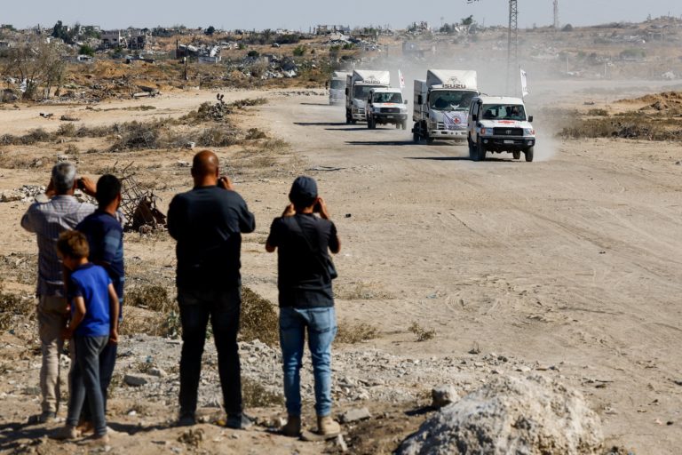Red Cross vehicles escort trucks transporting the bodies of Palestinians held by Israel during the war, in Khan Younis