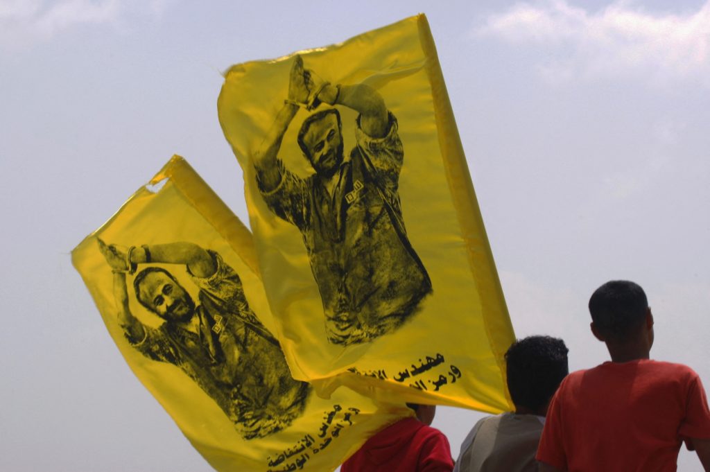 Palestinian youths carry flags during protest in the West Bank