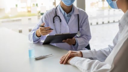 Midsection Of Doctor Explaining Patient In Hospital