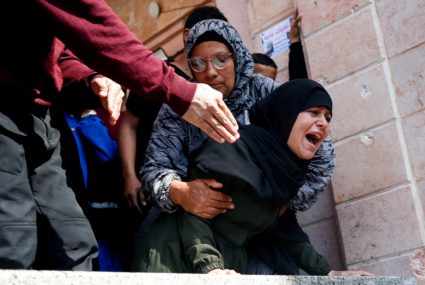 Mourners react next to the bodies of Palestinians killed in an Israeli strike