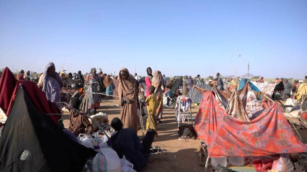 Displaced Sudanese gather and sit in makeshift tents after fleeing Al-Fashir city in Darfur