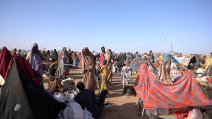 Displaced Sudanese gather and sit in makeshift tents after fleeing Al-Fashir city in Darfur