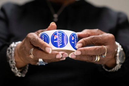 A poll manager unwinds "I Voted" stickers in anticipation of voters at a polling location in Spartanburg