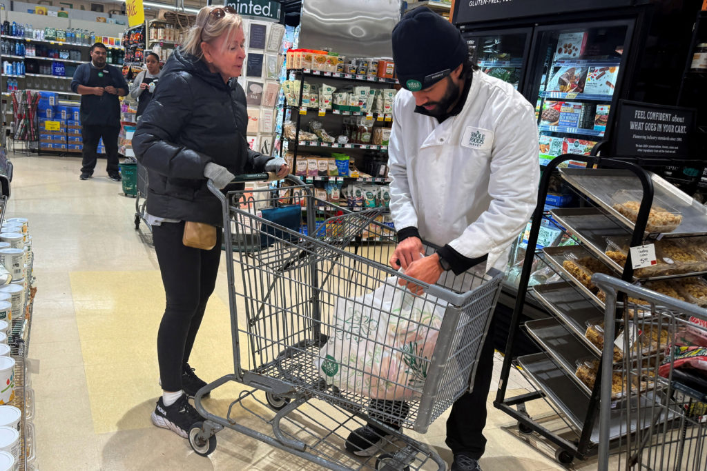 A woman has a Thanksgiving turkey bagged for purchase at a grocery store in Manhasset, New York