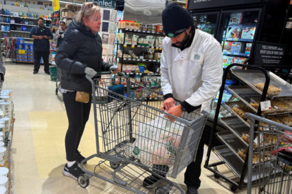 A woman has a Thanksgiving turkey bagged for purchase at a grocery store in Manhasset, New York