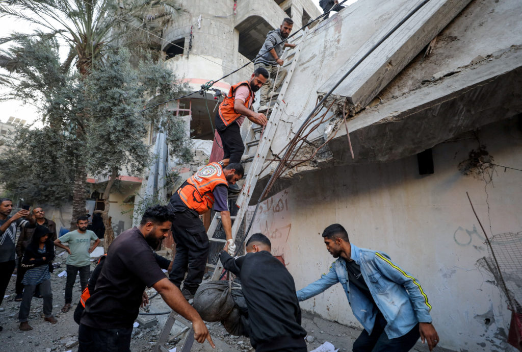 Palestinians inspect the site of an Israeli strike, in Gaza City
