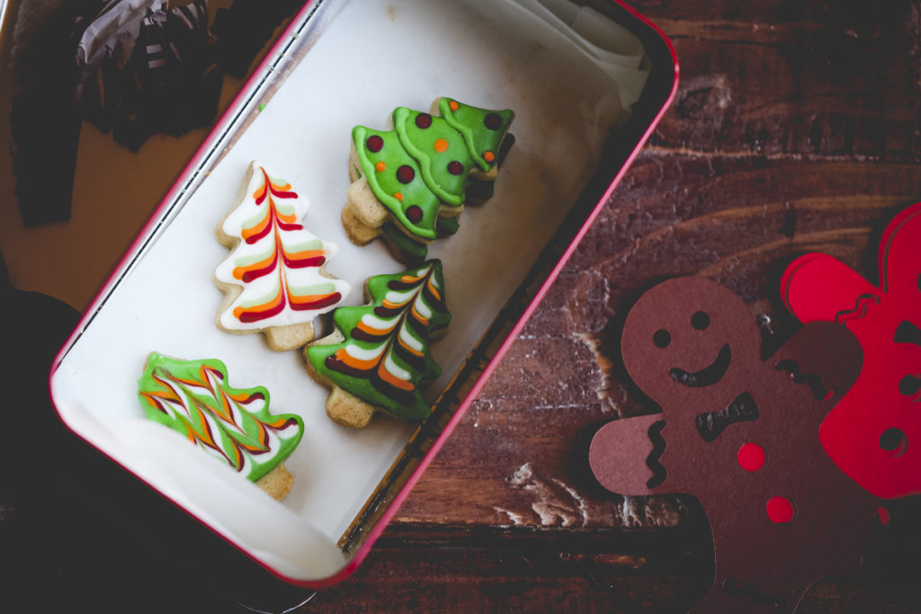 Overhead view of a tin of homemade Christmas cookies on a wooden table