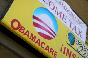 FILE PHOTO: A sign on an insurance store advertises Obamacare in San Ysidro