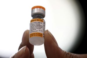 A nurse displays a tetanus, diphtheria and pertussis whooping cough vaccine at a free medical and dental health clinic in ...