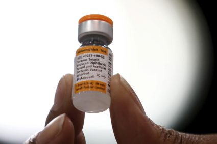 A nurse displays a tetanus, diphtheria and pertussis whooping cough vaccine at a free medical and dental health clinic in ...