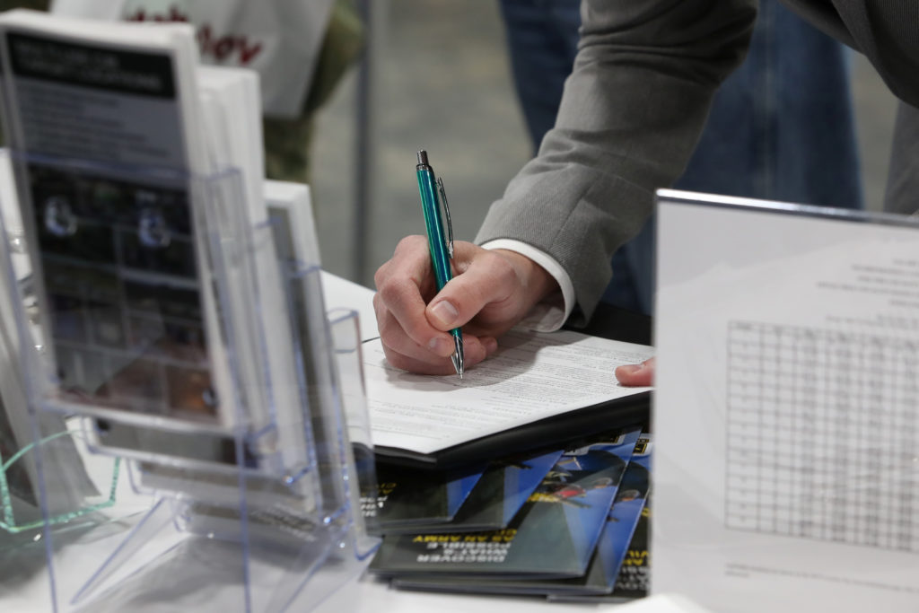 A veteran fills out a form at a military job fair in Sandy, Utah