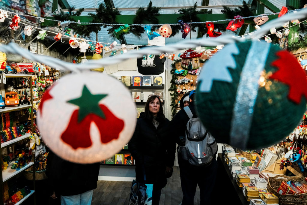 People shop for Christmas items in a holiday market in New York
