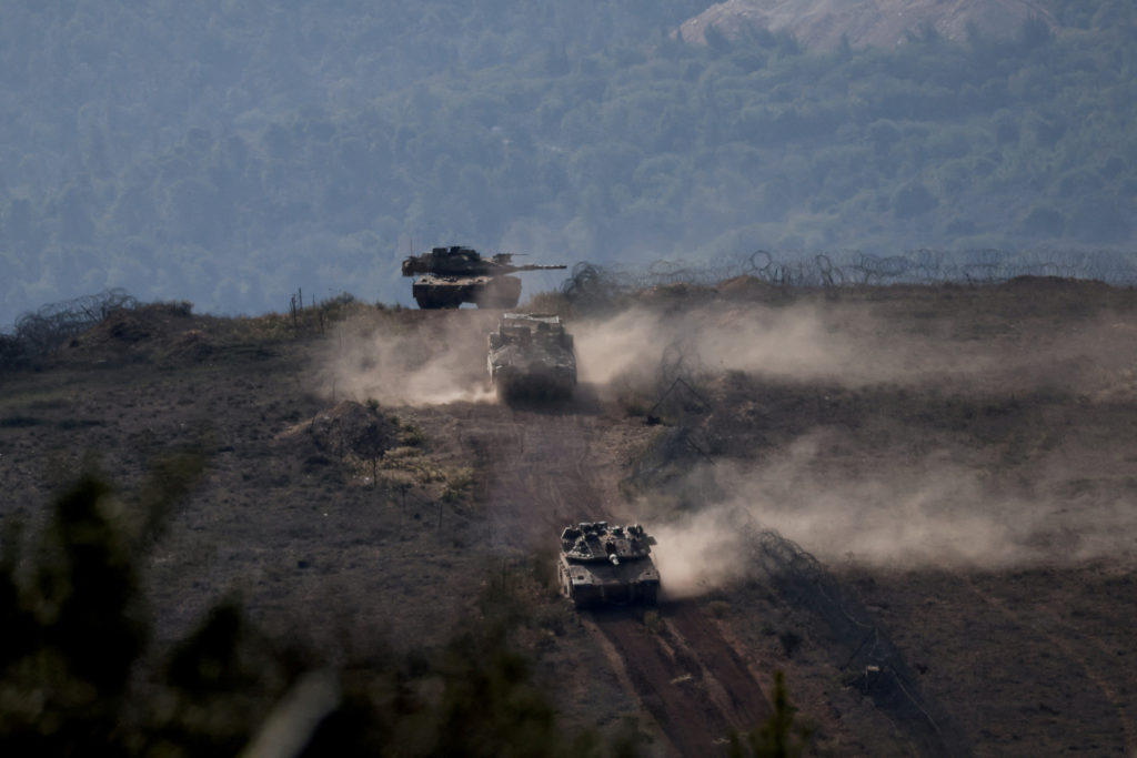 FILE PHOTO: Israeli military vehicles manoeuvre along the Israel-Lebanon border as seen from northern Israel