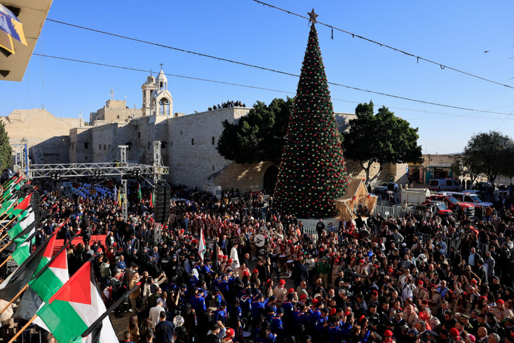 People gather next to the Christmas tree at Manger Square in Bethlehem