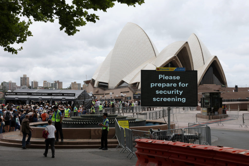 A sign reading "Please prepare for security screening" is displayed near a security checkpoint at the Sydney Opera House a...