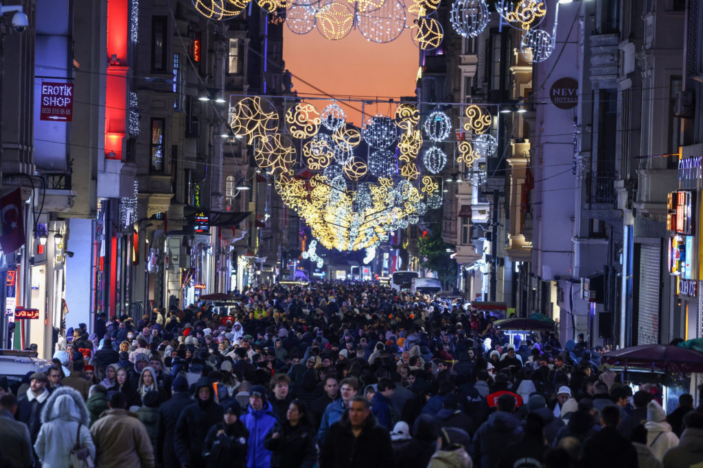 People walk along the main shopping and pedestrian street of Istiklal on New Year's Eve in central Istanbul