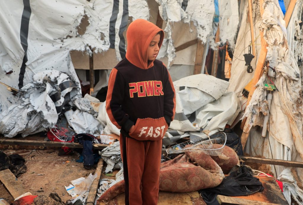 Palestinian child stands at the site of Wednesday’s Israeli strike on tents, in Khan Younis