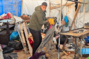 Palestinian man inspects the site of Wednesday's Israeli strike on tents, in Khan Younis
