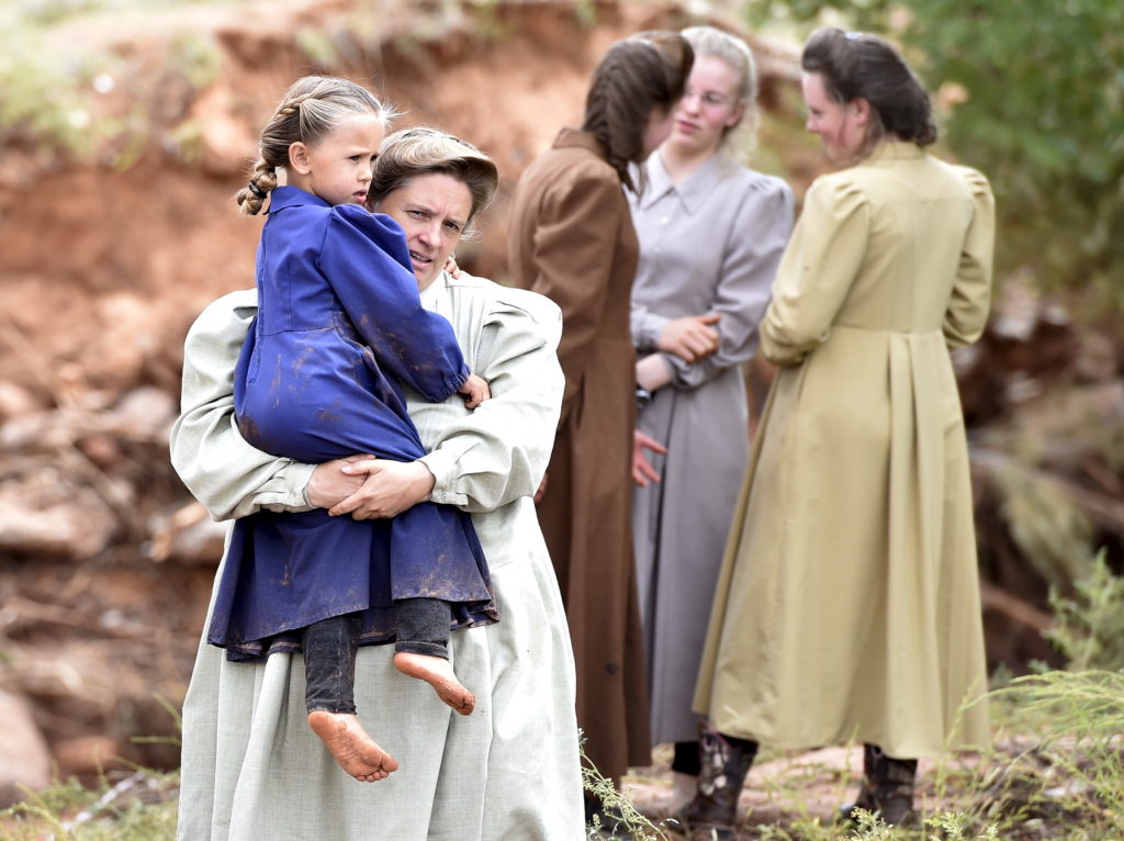 Residents watch rescuers search along the Short Creek after a flash flood in Hildale, Utah