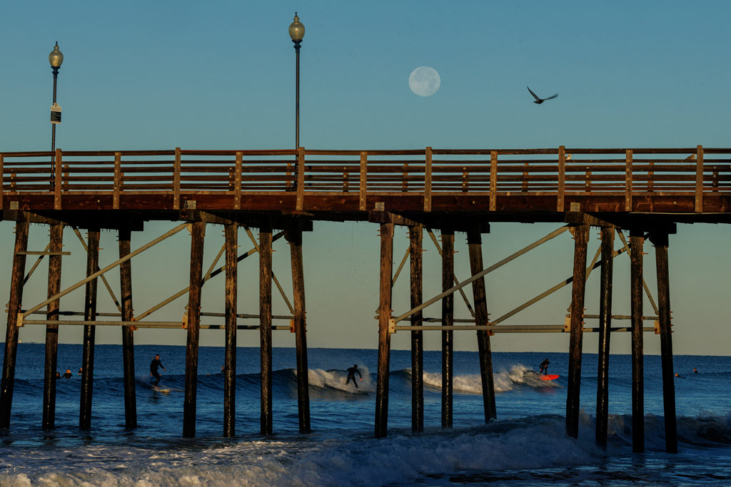 The Supermoon sets over surfers in California