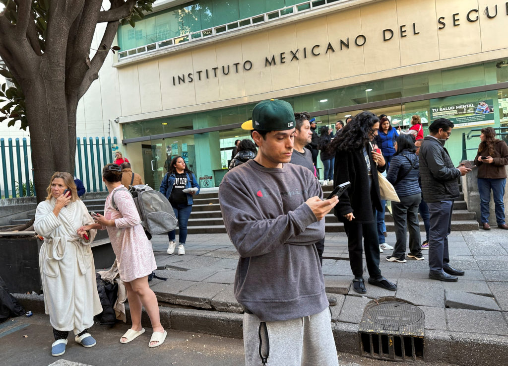 People wait outside their homes and buildings after an earthquake in Mexico City