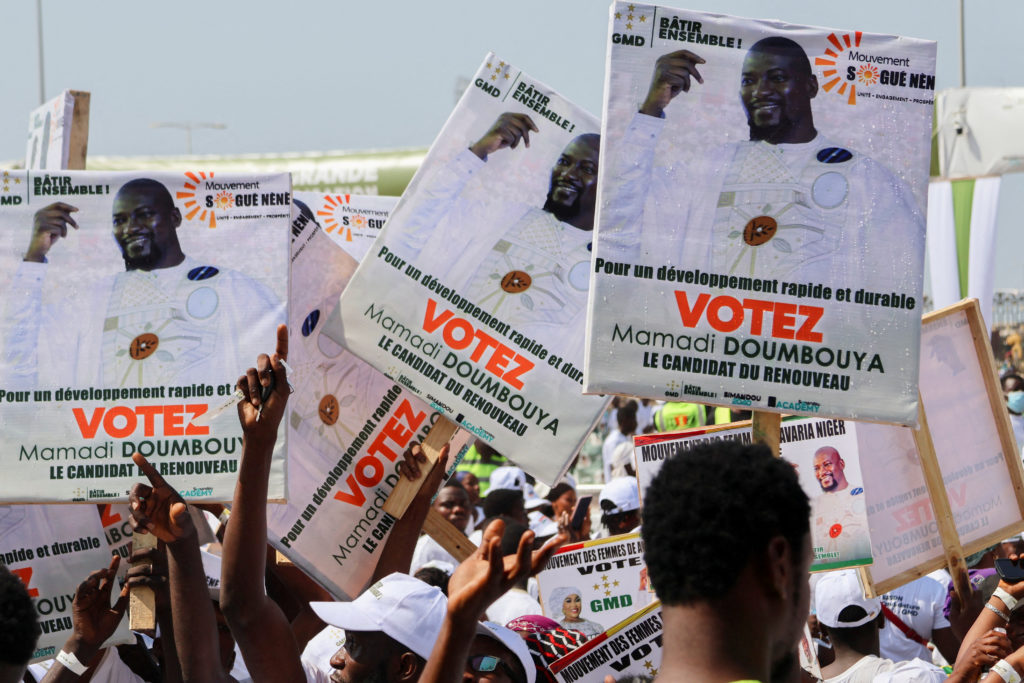 FILE PHOTO: Supporters of Guinean leader and presidential candidate Mamadi Doumbouya take part in his final campaign rally...
