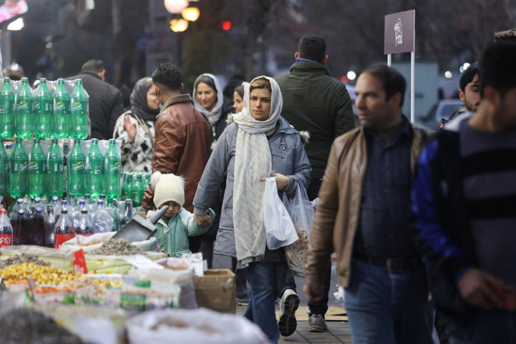 People walk on a street, as protests erupt over the collapse of the currency's value, in Tehran