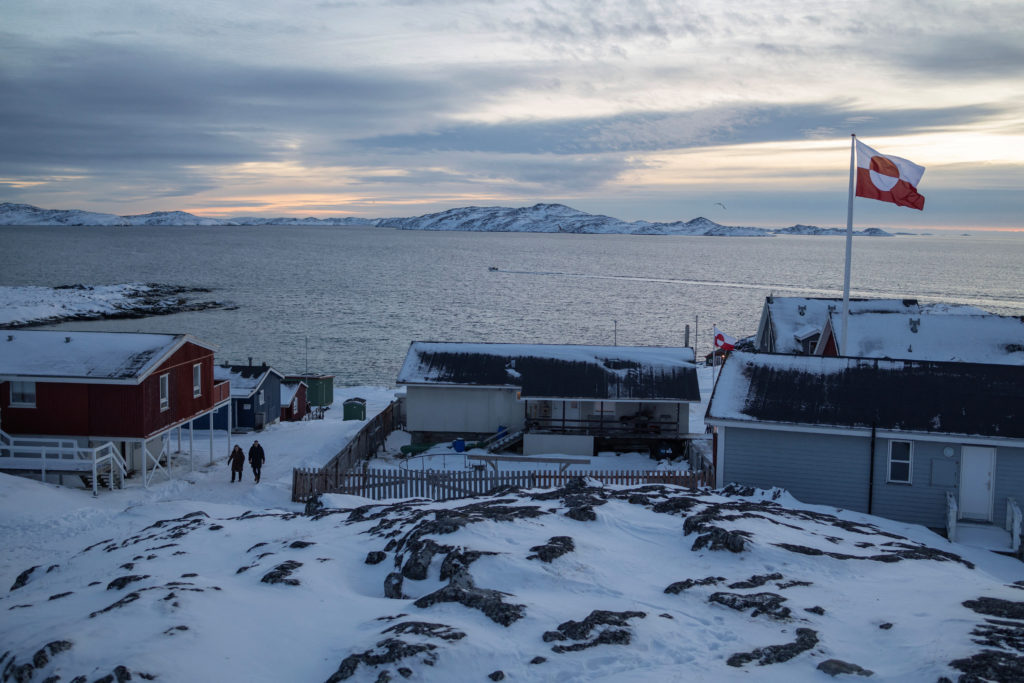 A Greenland flag flies as people walk on the day of a meeting between top U.S. officials and the foreign ministers of Denm...