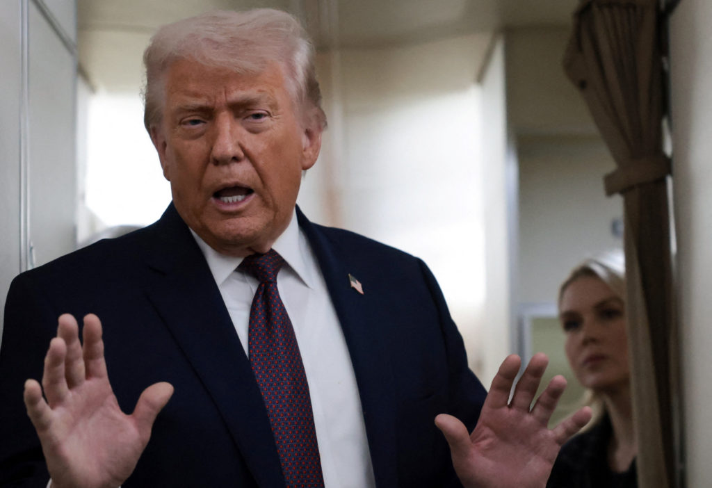 U.S. President Donald Trump speaks to reporters aboard Air Force One