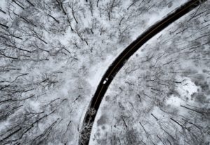 A drone view of a car driving through the snow covered woods of Blauvelt State Park after a winter storm bore down on the ...