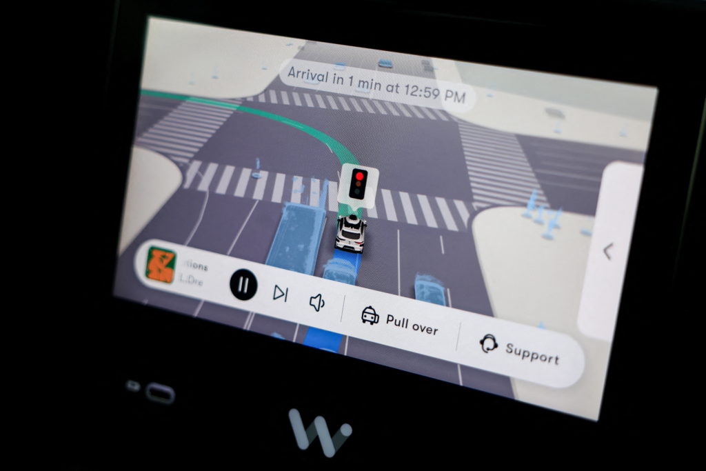 A self-driving Waymo car drives through Los Angeles