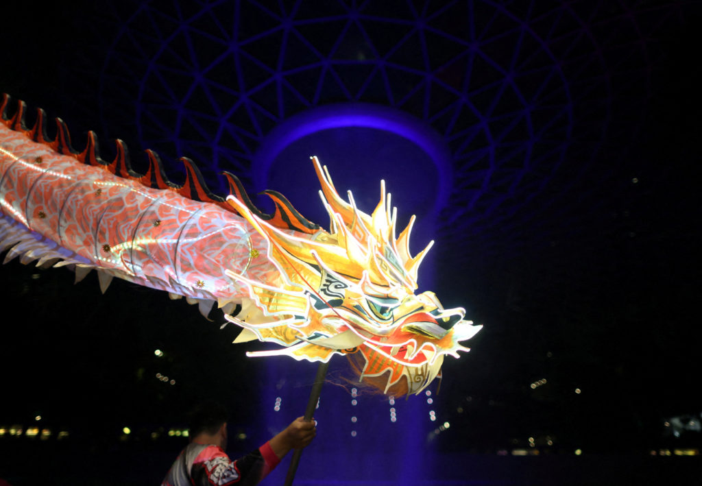 A dragon dance troupe performs an LED dragon dance on the eve of the Lunar New Year at Jewel Changi Airport in Singapore
