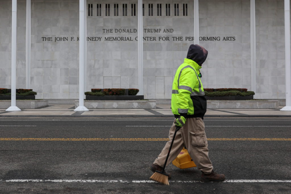 A worker walks in front of the recently renamed Donald J. Trump and John F. Kennedy Memorial Center for the Performing Art...