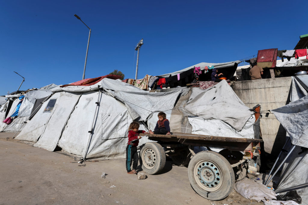 Palestinians displaced during the two-year Israeli offensive, shelter at a tent camp in Gaza City