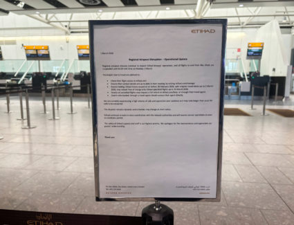 A sign displayed outside the Etihad airlines check in area informs of regional airspace disruptions to impact their operat...