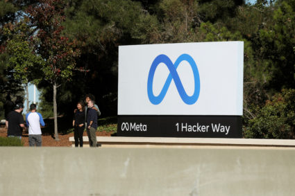 FILE PHOTO: People pose for a photo in front of Facebook's new rebrand logo Meta at its headquarters in Menlo Park
