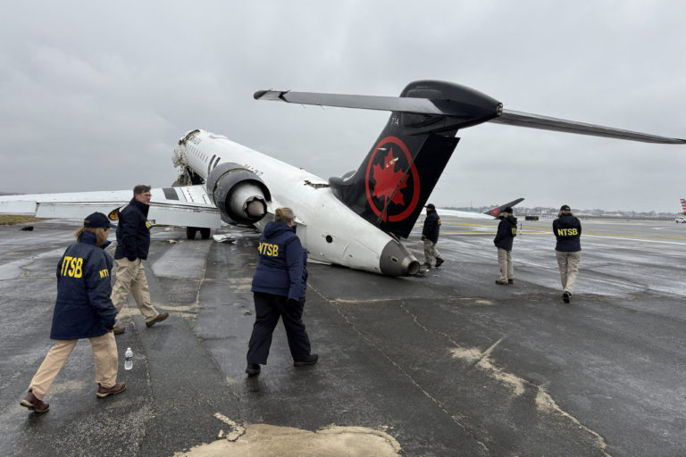 NTSB investigators inspect the wreckage of an Air Canada Express jet at New York's LaGuardia Airport