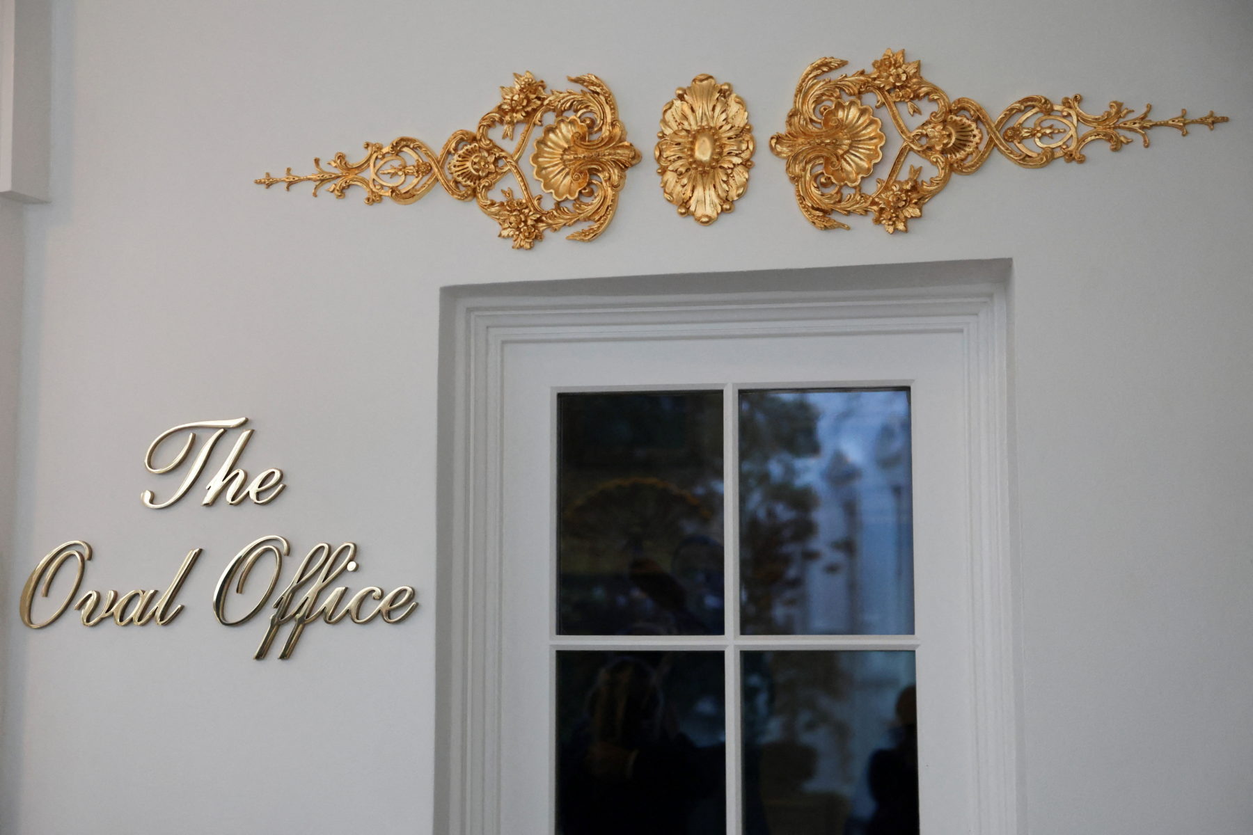 A new sign and gold ornamentation adorn the door of the Oval Office at the White House in Washington