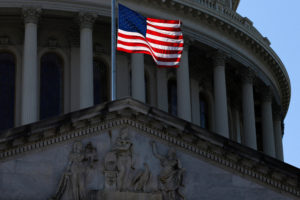 The U.S. flag flies in front of the dome atop the U.S. Capitol in Washington