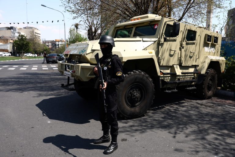 A member of a police force stands guard on a street, amid the U.S.-Israeli conflict with Iran, in Tehran