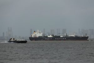 A hovercraft moves past the Jag Vasant vessel transferring LPG at a port after transiting the Strait of Hormuz amid supply...
